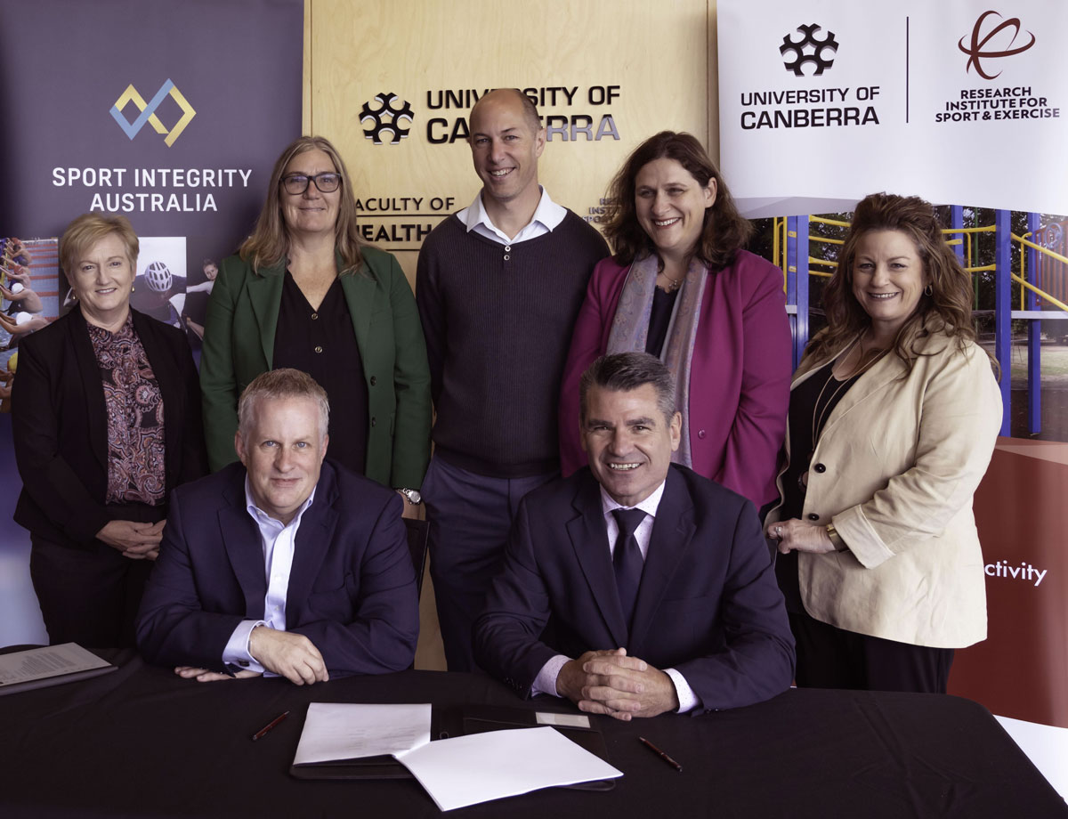 Attendees signing a joint PhD research project on cyberbullying with the University of Canberra