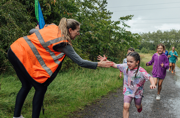 volunteer high fiving kids