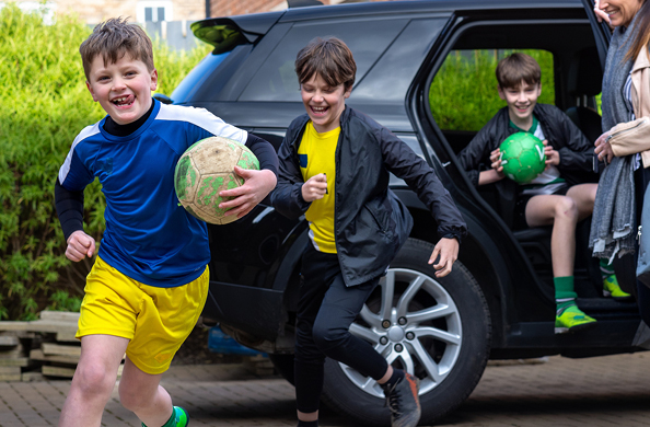 Parent with kids in front of a car