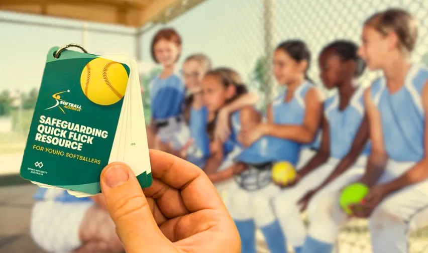 Safeguarding Quick Flick Pocket Cards held in a hand in front of a team of softball players