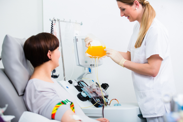 Nurse showing donor their collected plasma during donation procedure