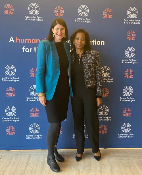 Sport Integrity Australia Human Rights Advisor Nikki Dryden and French Ministry of Sport Delegate Marjorie Guillaume stand in front of a backdrop for the Centre for Sport & Human Rights