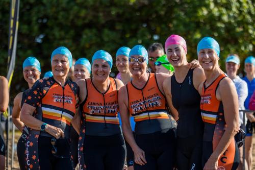 Triathletes in swimming gear pose for a group photo during a race