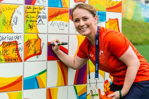 Kate McLoughlin signing a wall at the Rio 2016 Paralympics as the first female Chef de Mission