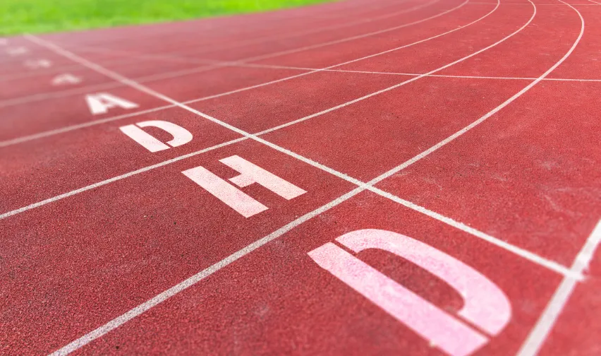 ADHD letters spelt out in white on an athletics running track