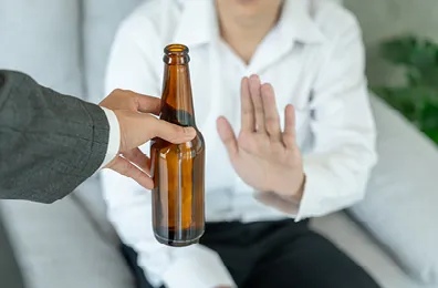 person refusing a bottle of alcohol