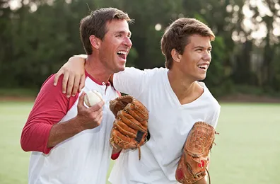 Father and son with baseball gloves cheering