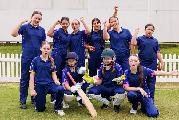 girls cricket team wearing purple cheering